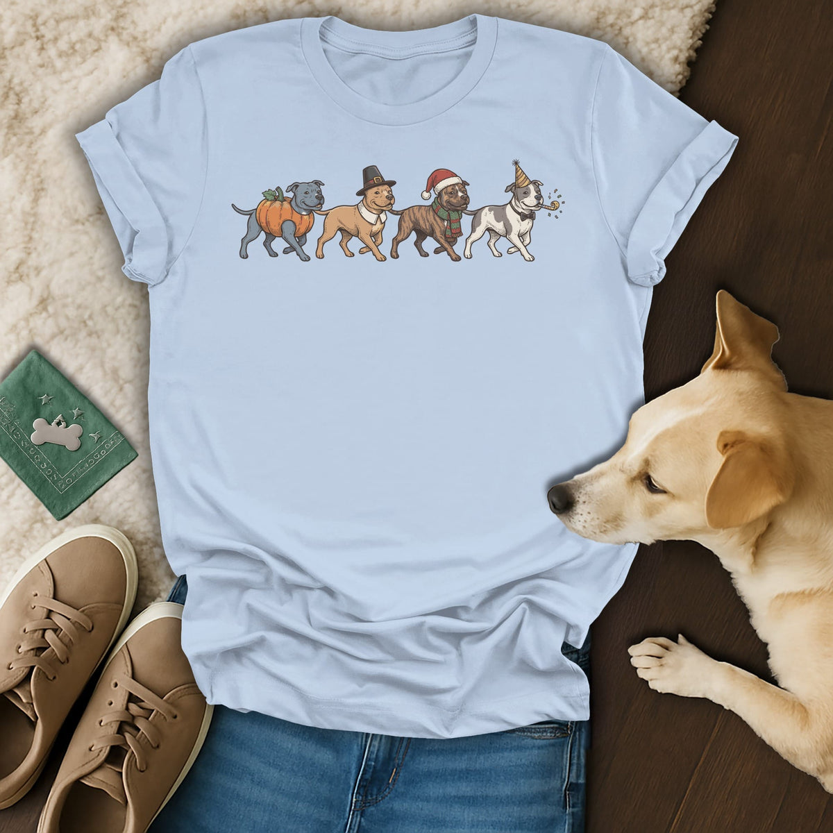 Light blue t-shirt with cartoon dogs in holiday costumes: pumpkin, pilgrim, Santa, and party.