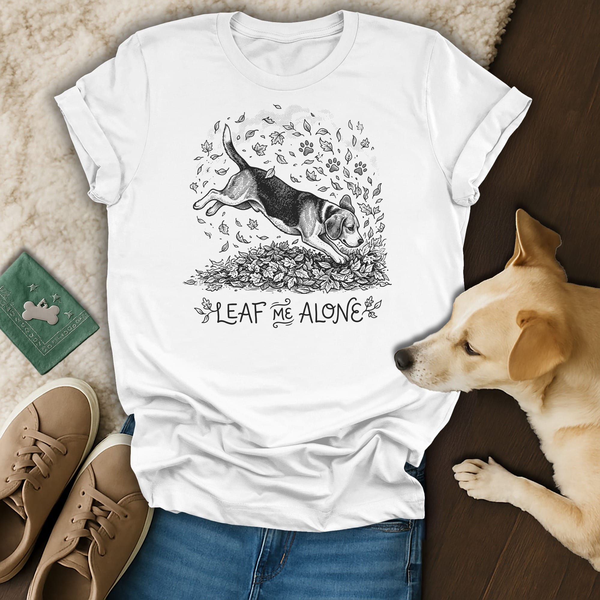 White t-shirt with a beagle jumping in fall leaves and the text "Leaf Me Alone".