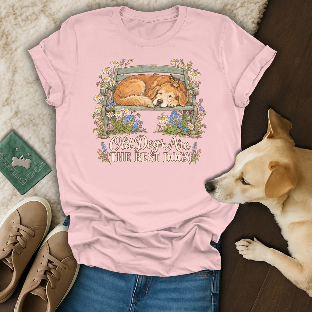 A pink t-shirt with a graphic of a sleeping dog on a bench and the text Old Dogs Are The Best Dogs.