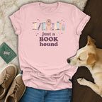 Pink t-shirt with a dog and books graphic reading "just a BOOK hound".
