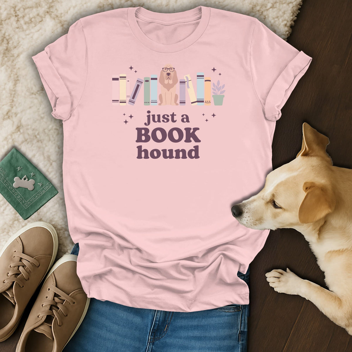 Pink t-shirt with a dog and books graphic reading "just a BOOK hound".