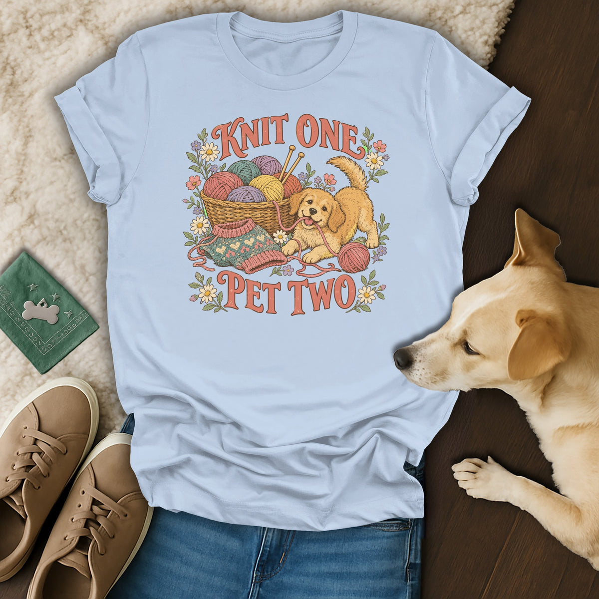Light blue t-shirt featuring a puppy playing with yarn and the text Knit One Pet Two.
