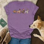 Purple t-shirt featuring four dogs dressed for holidays: pumpkin, pilgrim, Santa, and party.