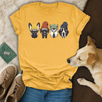 Four dogs wearing colorful beanies on a yellow t-shirt.