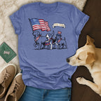 Three dogs in patriotic attire march with a flag and drum.