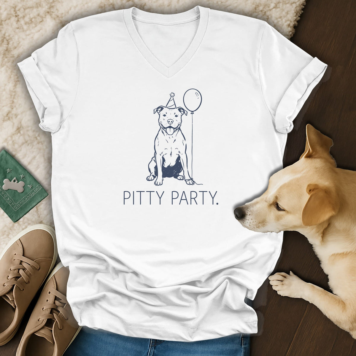 White t-shirt with navy line art of a dog in a party hat holding a balloon.