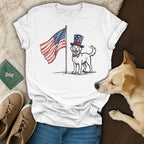 White t-shirt with dog wearing Uncle Sam hat and bow tie near American flag.