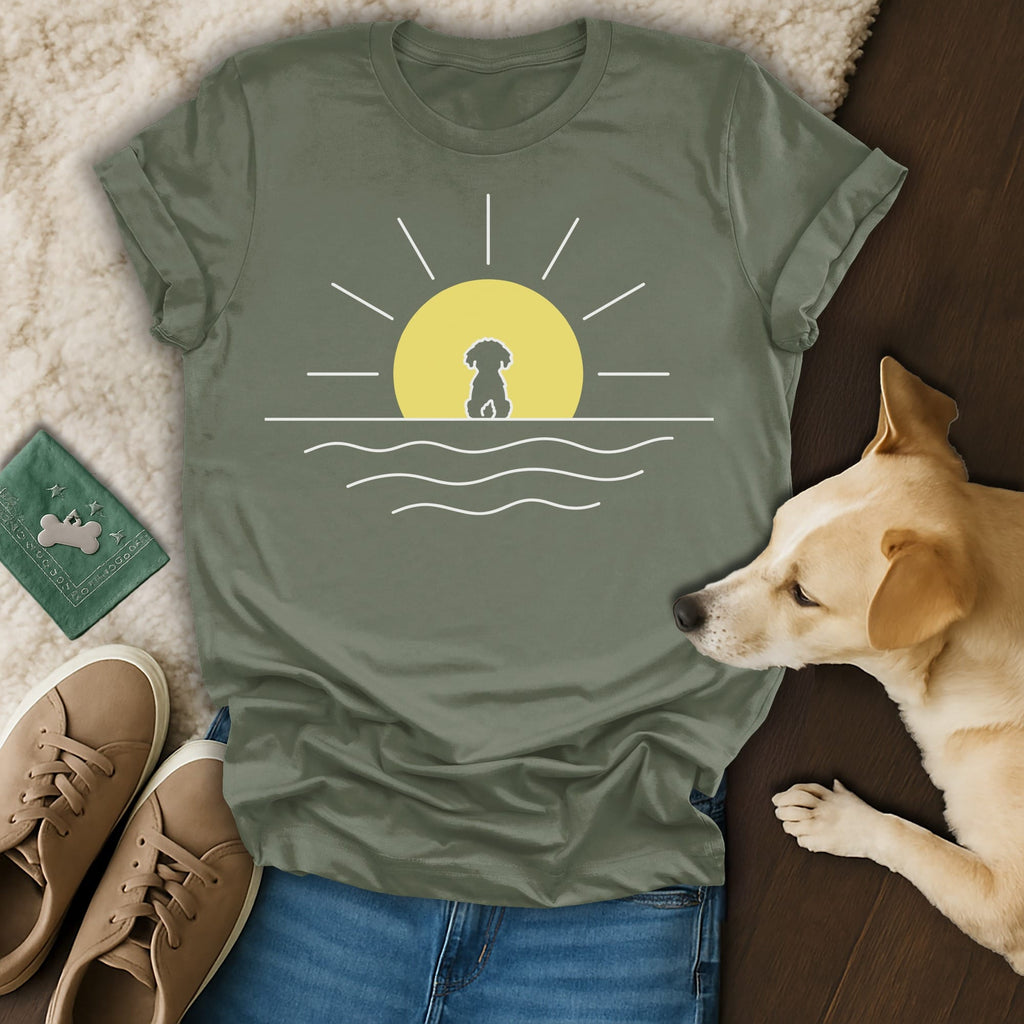 Olive green t-shirt with a dog silhouette against a sunset over water design.