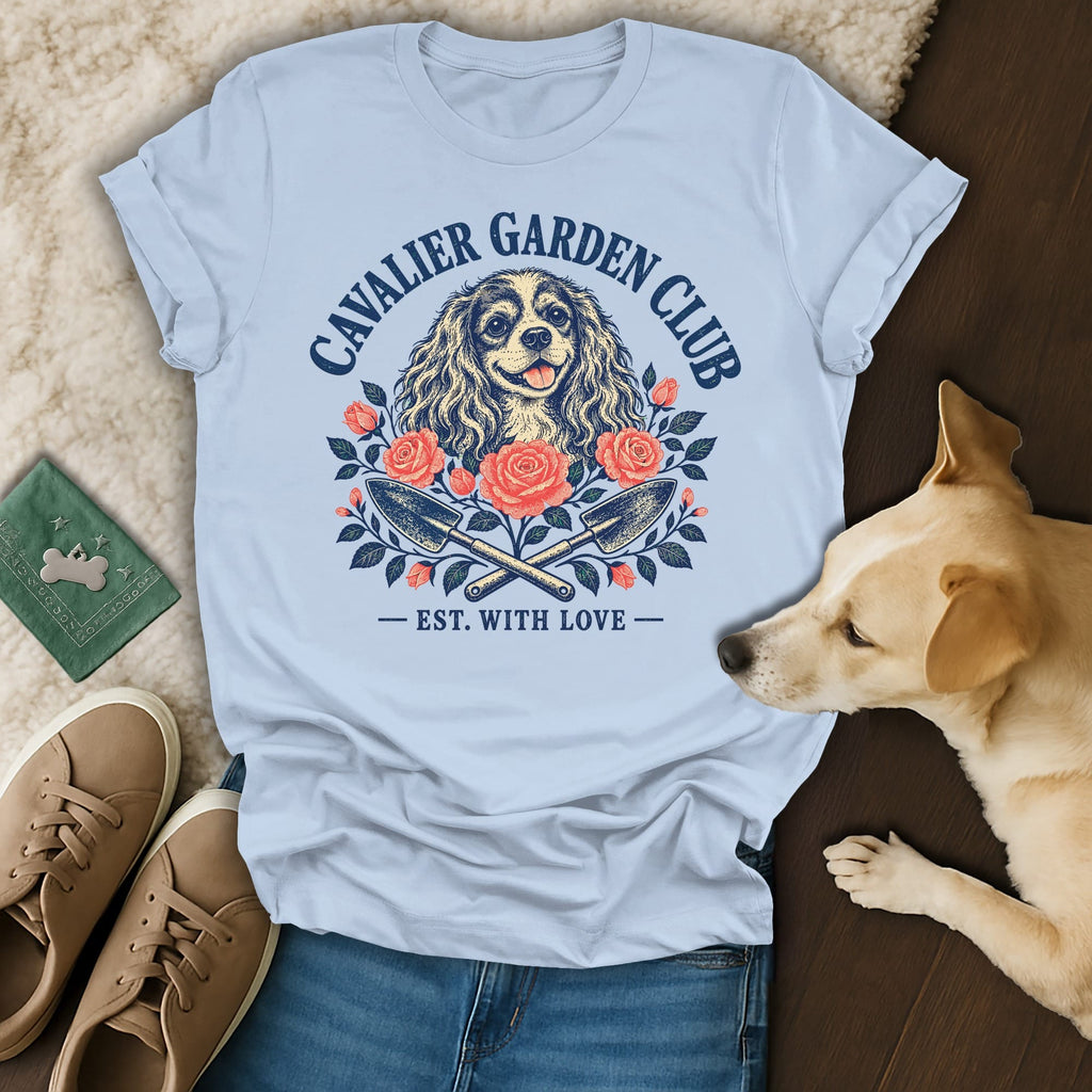 Light blue t-shirt featuring a Cavalier King Charles Spaniel graphic with flowers and gardening tools.