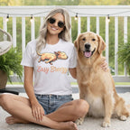 Woman wearing a white t-shirt with a cartoon dog and "Easy Breezy" text sits with golden retriever.
