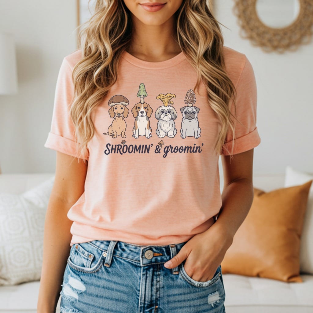 Peach t-shirt with four dogs wearing mushrooms and text "SHROOMIN' & groomin'".