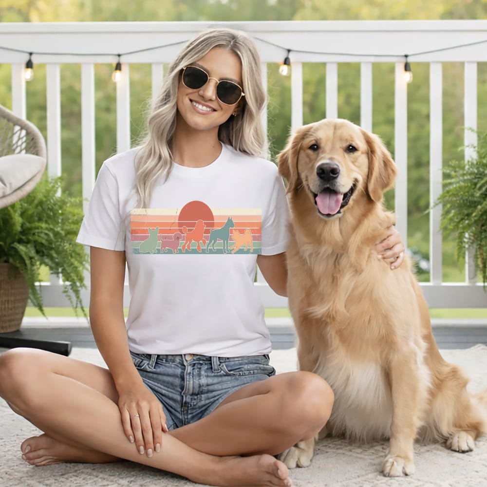 Woman wearing white t-shirt with dog silhouette graphic, sitting with golden retriever.