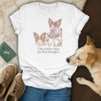 White t-shirt with butterfly girl and dog illustration and text "Life is better when you float through it."