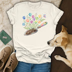 White t-shirt with colorful paw print flowers and a gardening trowel.