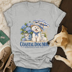 Heather gray V-neck T-shirt featuring a graphic of a dog, hydrangeas, umbrella, and text that reads Coastal Dog Mom.
