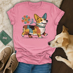 Corgi wearing a collar, holding a flower, on a pink t-shirt.