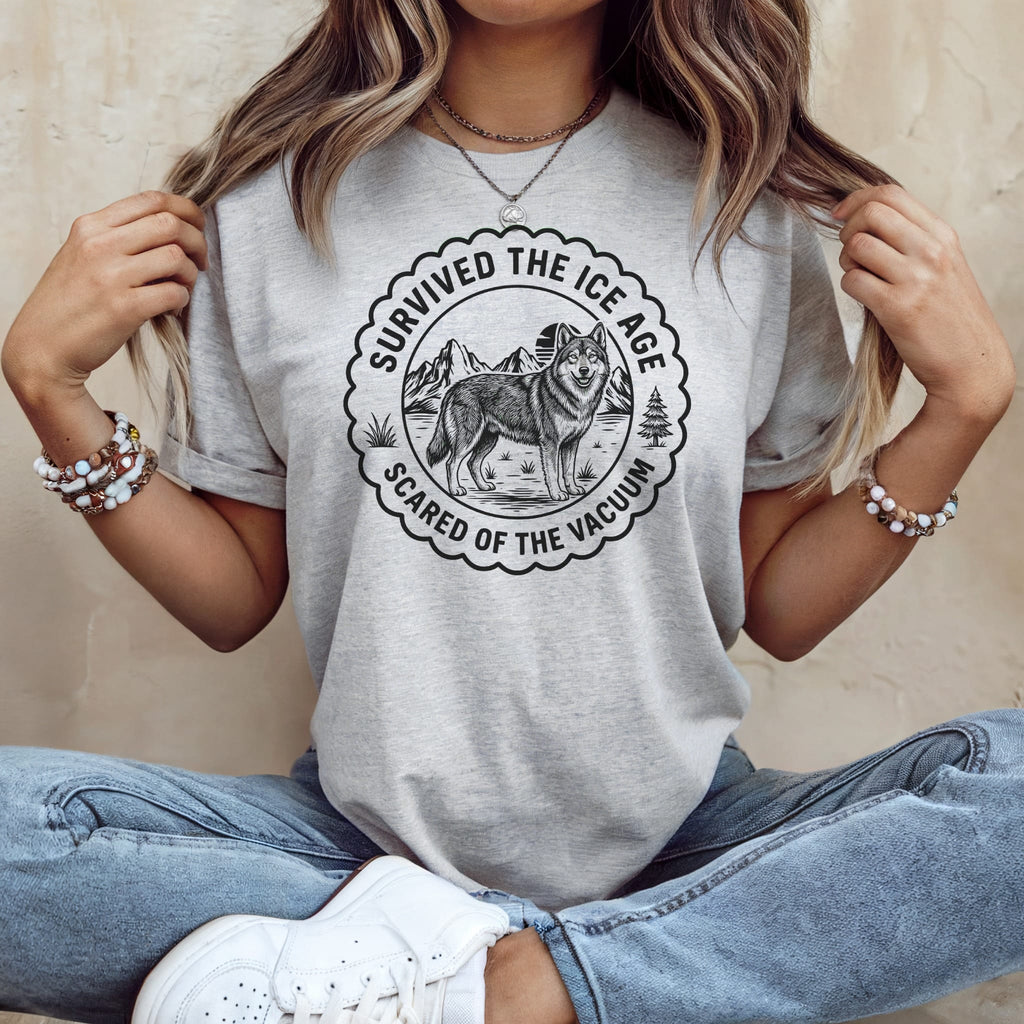 Light grey t-shirt with graphic of a wolf and text "Survived the Ice Age, Scared of the Vacuum".