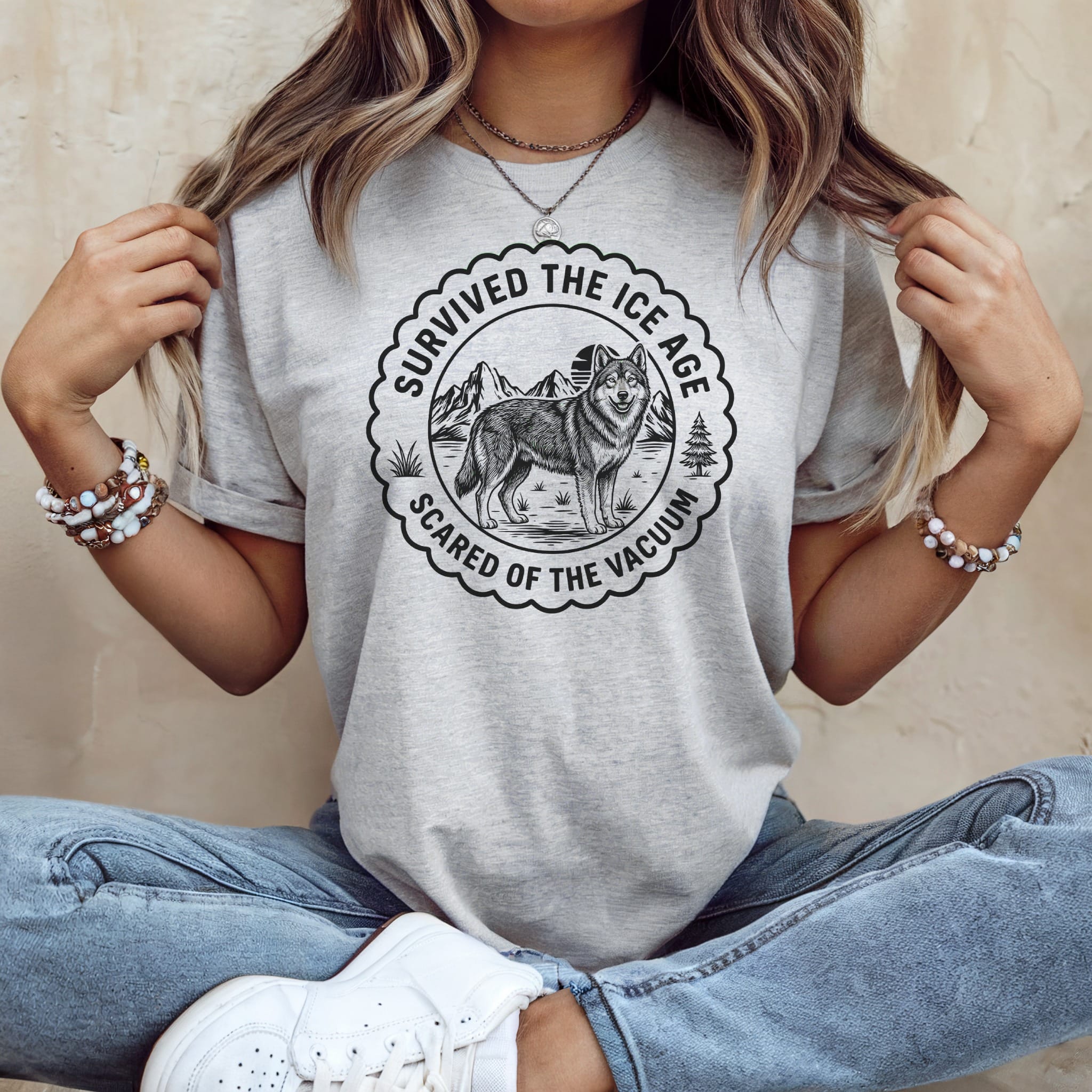 Light grey t-shirt with graphic of a wolf and text "Survived the Ice Age, Scared of the Vacuum".