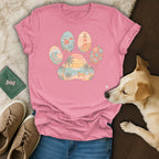 Pink t-shirt featuring a paw print with beach scenes inside each toe and the palm.