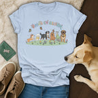 Light blue t-shirt with "PAWS IN BLOOM" and illustrated dogs in a field.