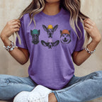 Purple t-shirt with four cartoon dog faces wearing beanies.