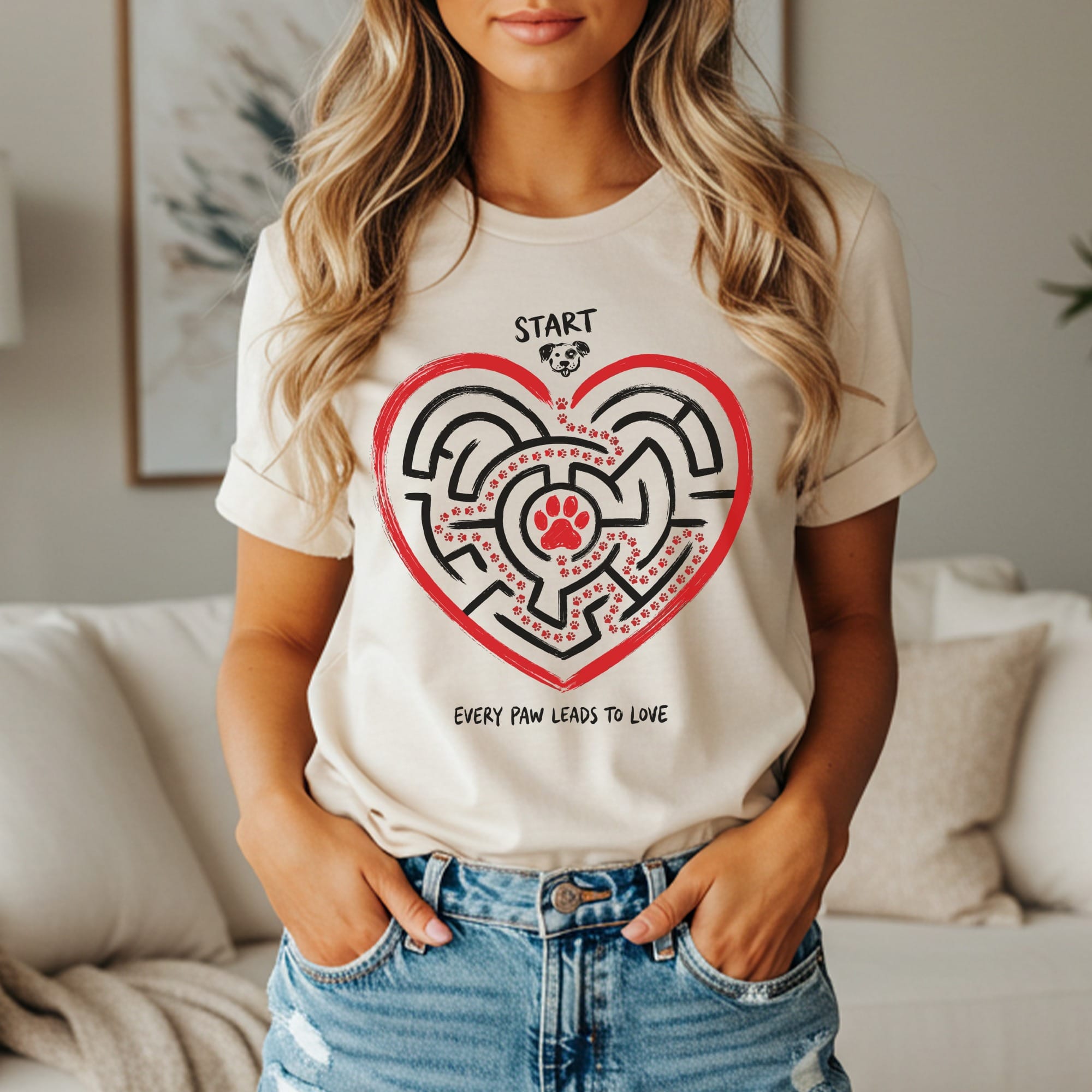 Beige t-shirt with a heart-shaped maze graphic and the text "START" and "EVERY PAW LEADS TO LOVE."
