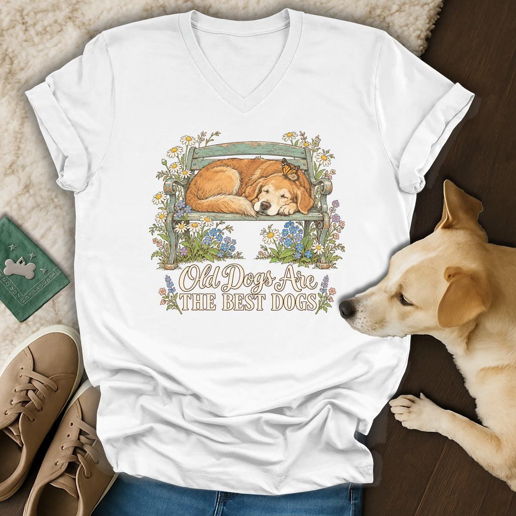 White v-neck t-shirt featuring a graphic of a sleeping golden retriever on a bench with flowers and text.