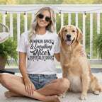 Woman wearing a t-shirt with "Pumpkin Spice & Everything Nice Especially Dogs" text.