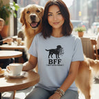 Woman with dog wearing a light blue t-shirt with a black dog graphic and "BFF BEST FETCH FRIEND" text.
