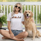 White t-shirt with dachshunds dressed for holidays, worn by a woman next to a golden retriever.