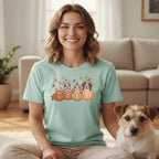 Light mint t-shirt with cartoon dogs in pumpkins graphic and autumn leaves.