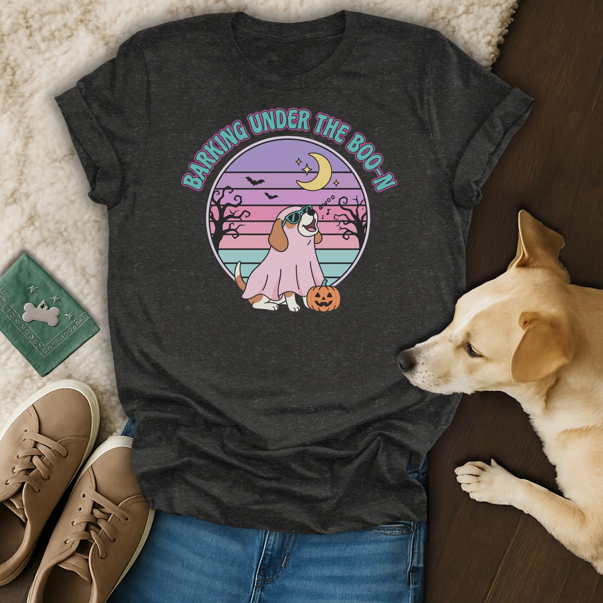 Dark gray t-shirt with "Barking Under The Boo-N" and dog in ghost costume graphic.