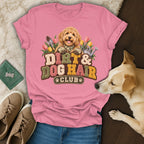 Pink t-shirt with a graphic of a golden doodle gardening and text reading Dirt & Dog Hair Club.