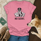 Pink t-shirt with black and white dog illustration and text "NO SAINT."