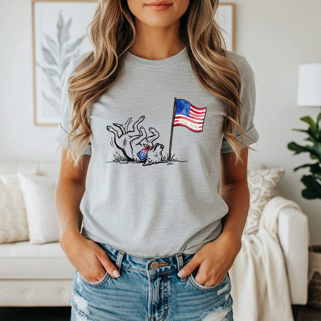 Dog wearing American flag costume behind a flag pole with "1776-2026" text.
