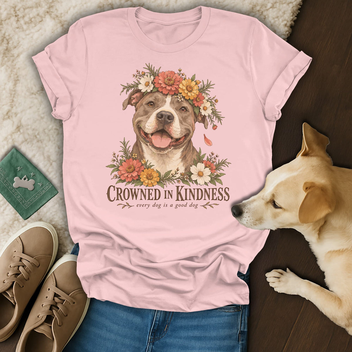 A pink t-shirt featuring a pit bull graphic surrounded by flowers and the text Crowned in Kindness.