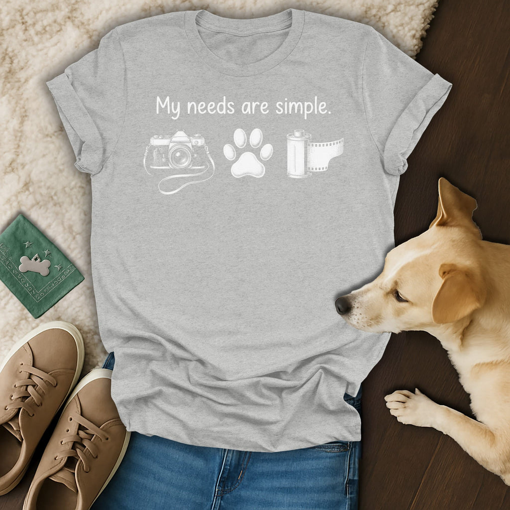 Grey t-shirt with text "My needs are simple." and icons of a camera, paw, and film roll.