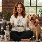 Woman with a dog and a duck graphic on her shirt, sitting with two dogs.
