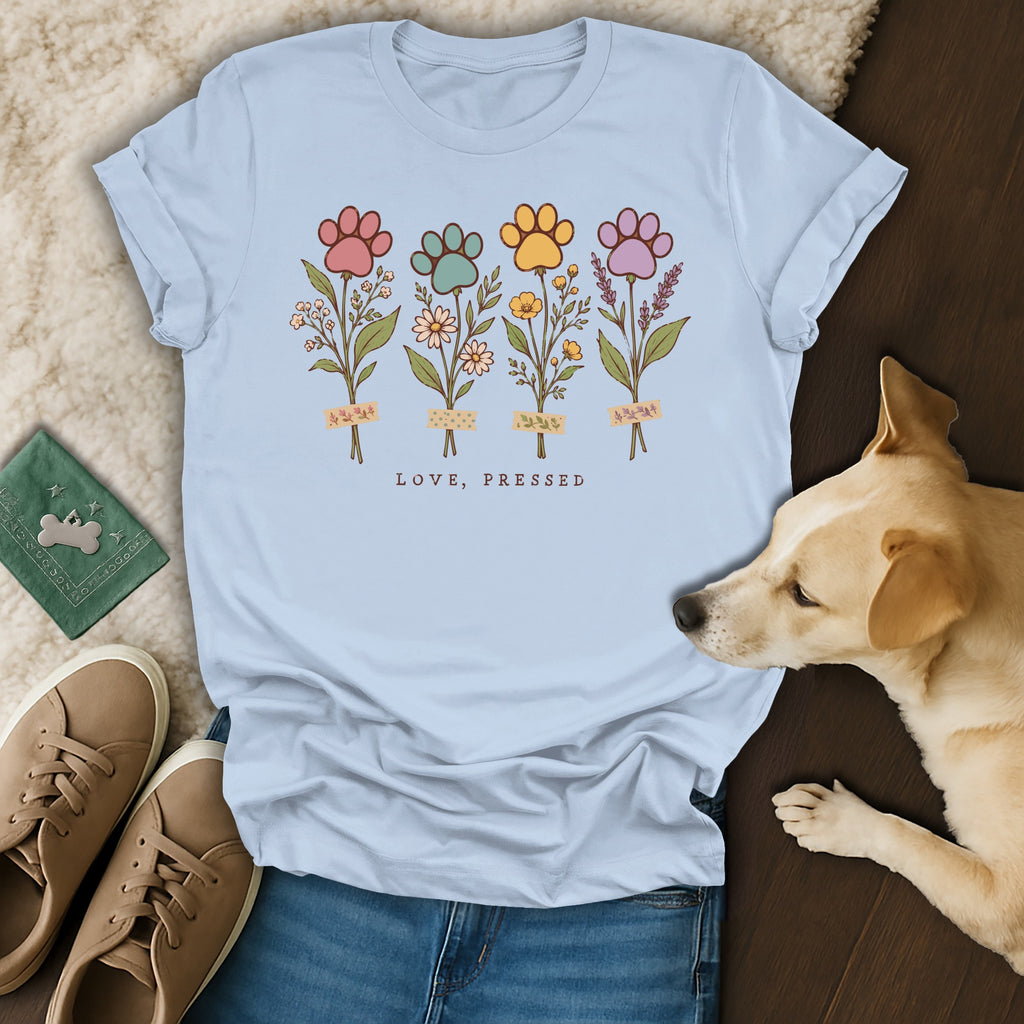 Light blue t-shirt displaying a graphic of four paw print flowers with the text LOVE, PRESSED.