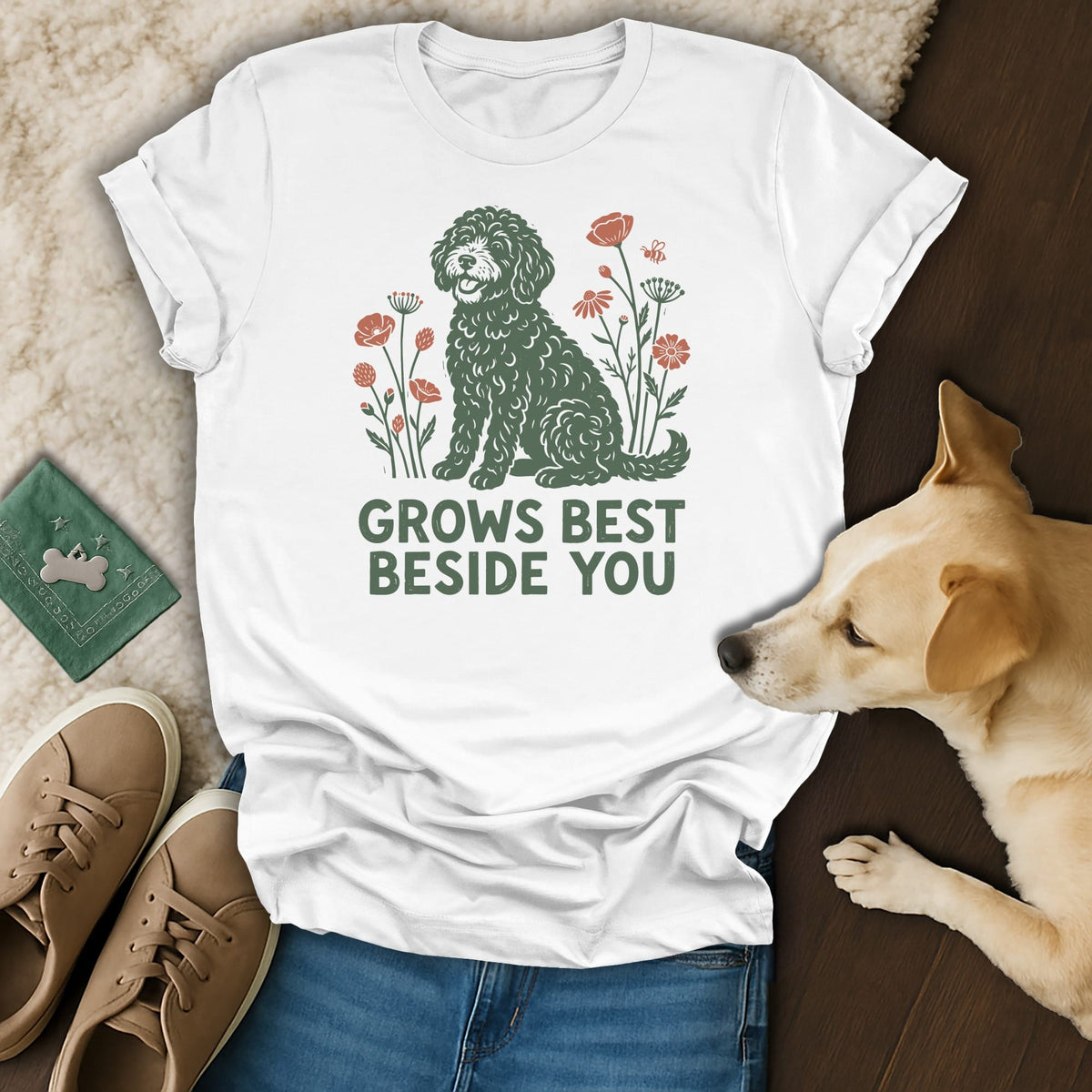 A white t-shirt with a green doodle dog graphic, floral elements, and the text GROWS BEST BESIDE YOU.