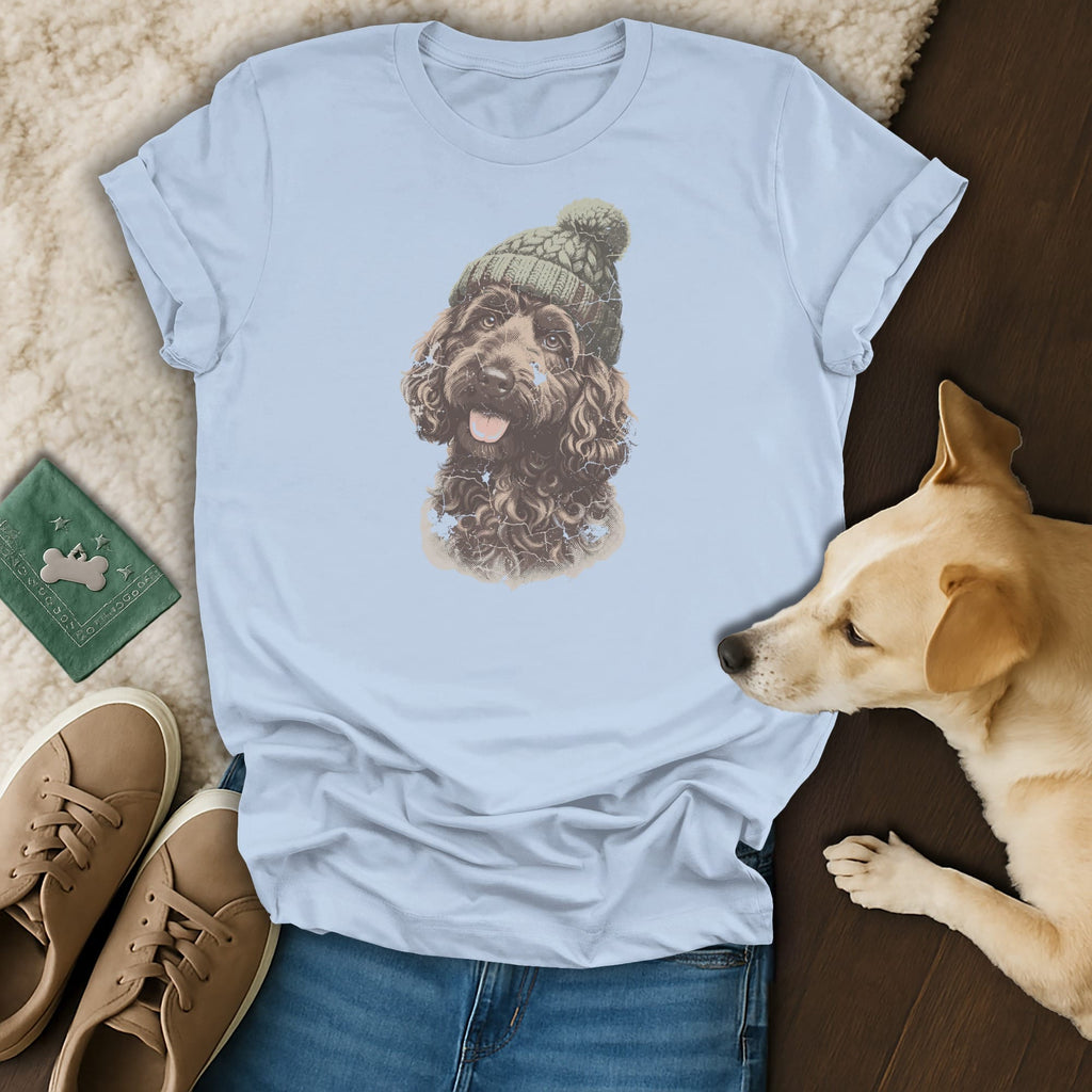 Light blue t-shirt with a graphic of a brown dog wearing a green knitted hat.