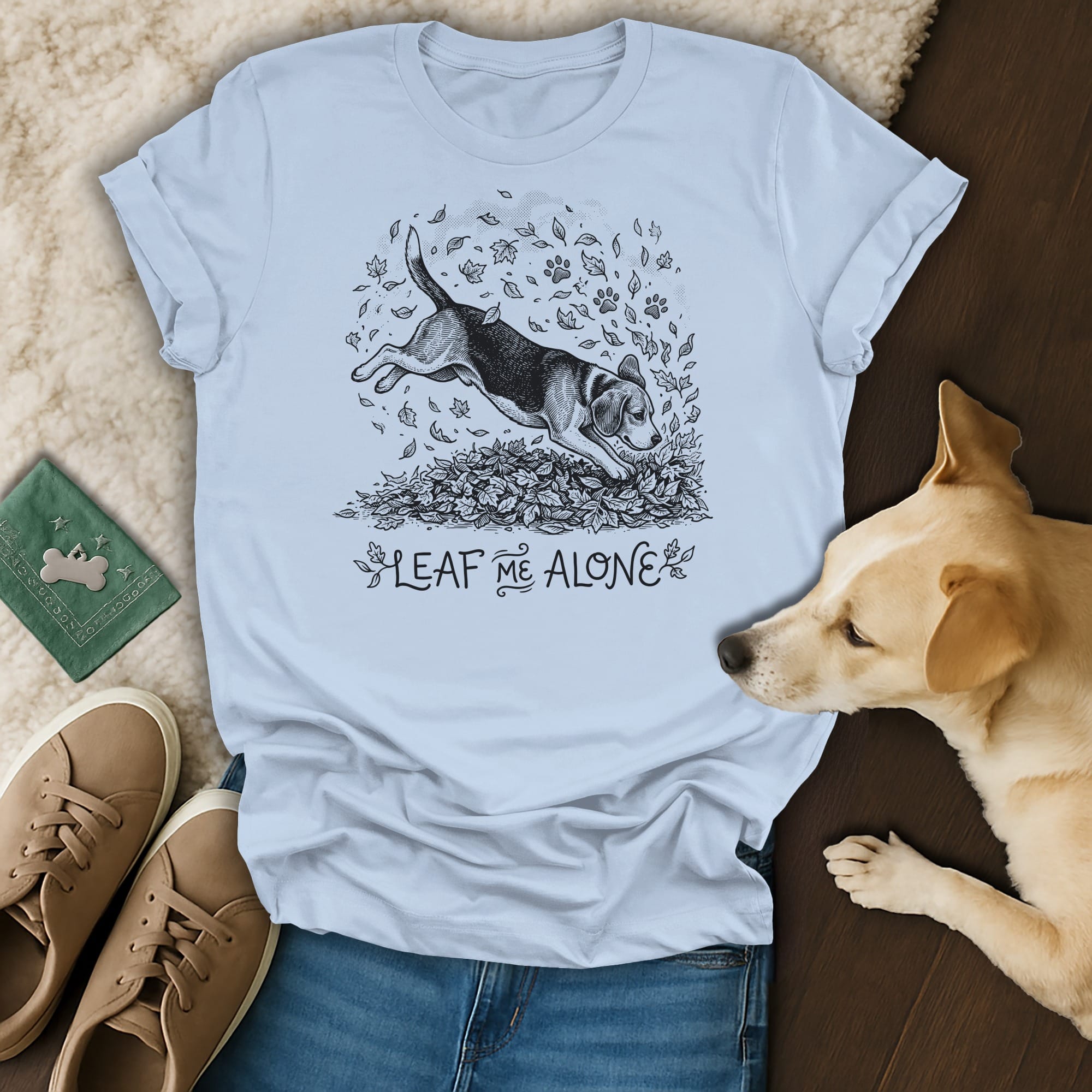 Light blue t-shirt with beagle jumping in leaves, saying "Leaf Me Alone".