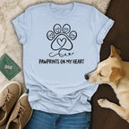 Light blue t-shirt with black paw print and heart design, text "Pawprints on my heart".