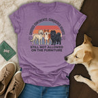 Three dogs on a t-shirt with text: "Crossed Continents. Conquered Hearts. Still Not Allowed on the Furniture."