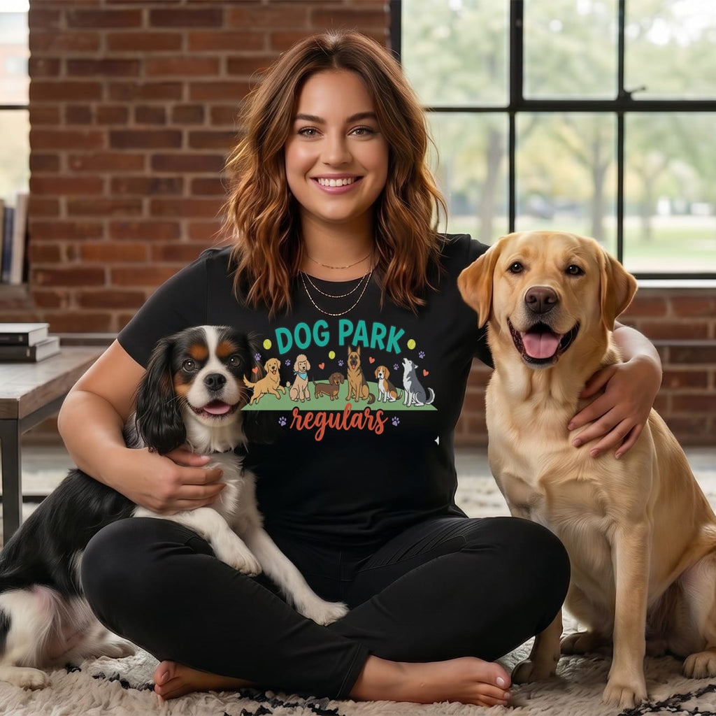Woman with two dogs wearing a t-shirt with "Dog Park" and dog illustrations.