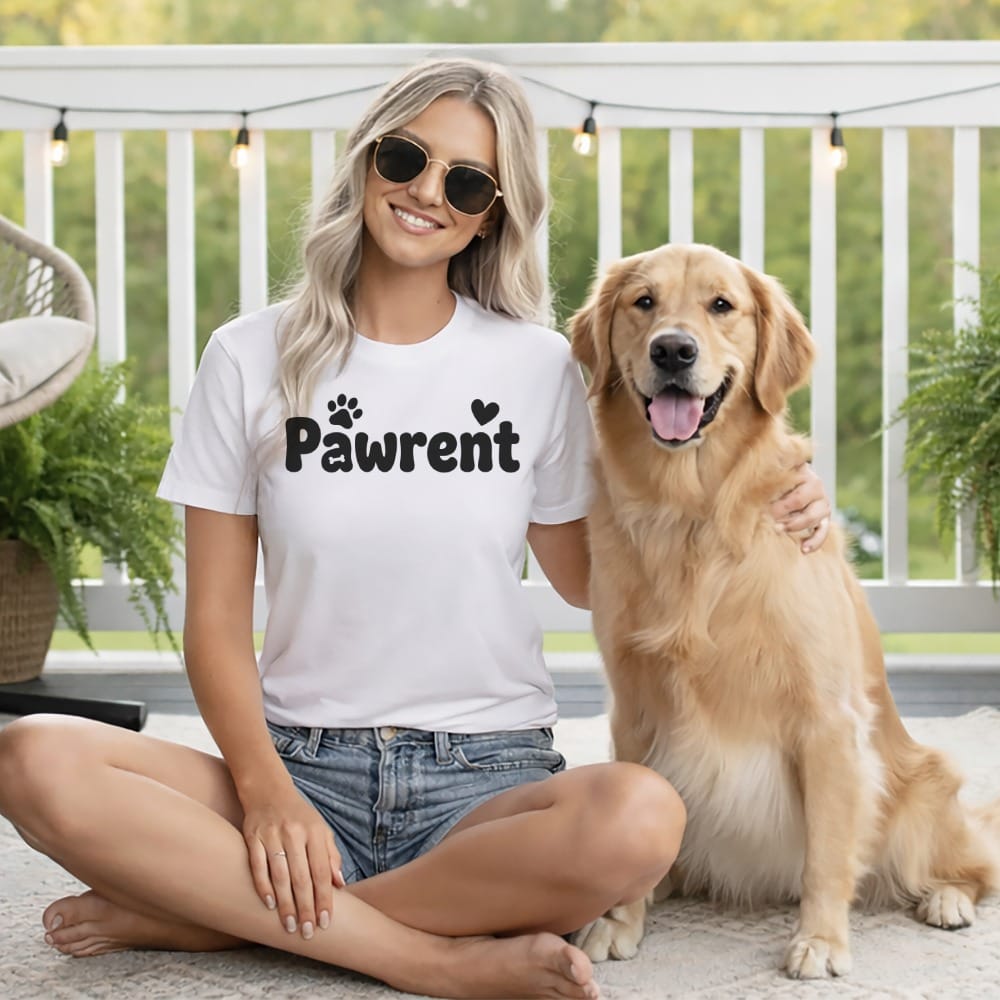 Woman wearing a "Pawrent" t-shirt sitting with a golden retriever dog.