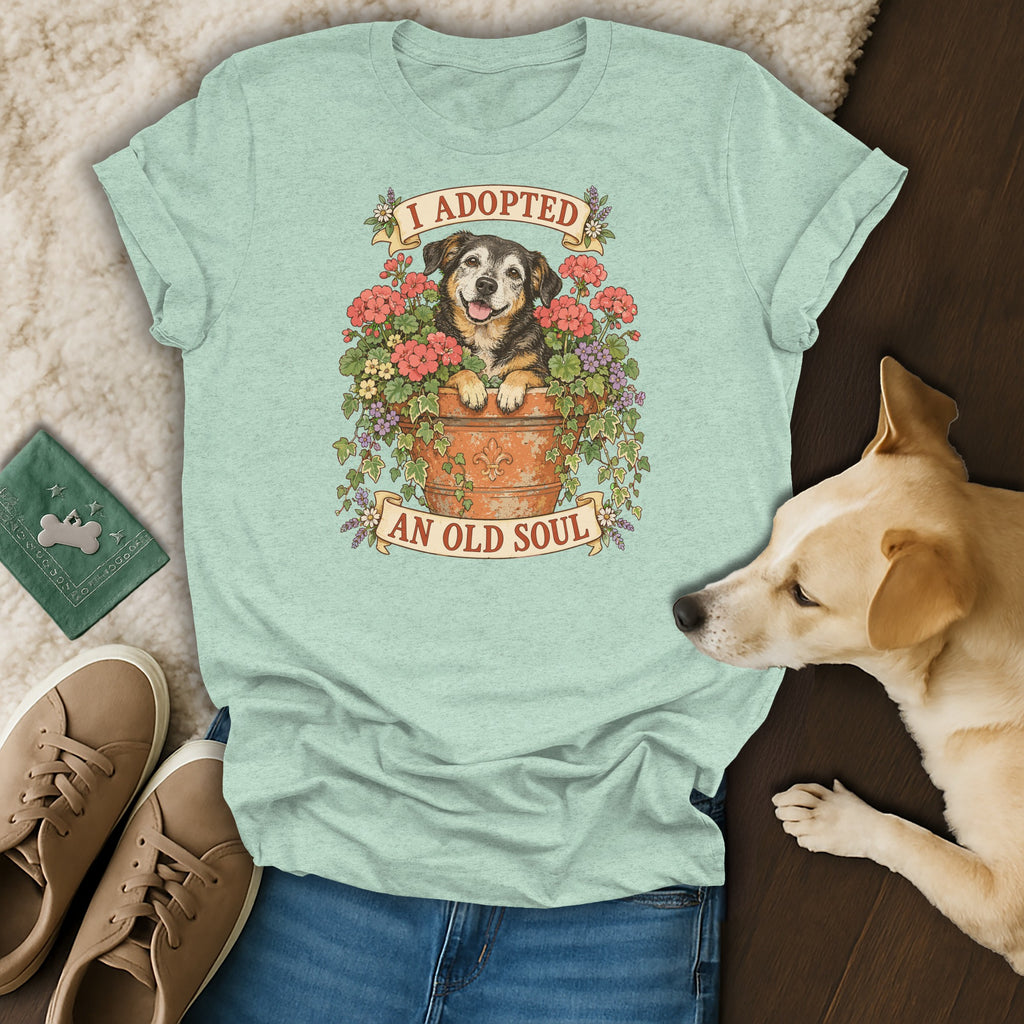 A light green t-shirt with a graphic of a dog in a flower pot and the text I ADOPTED AN OLD SOUL.