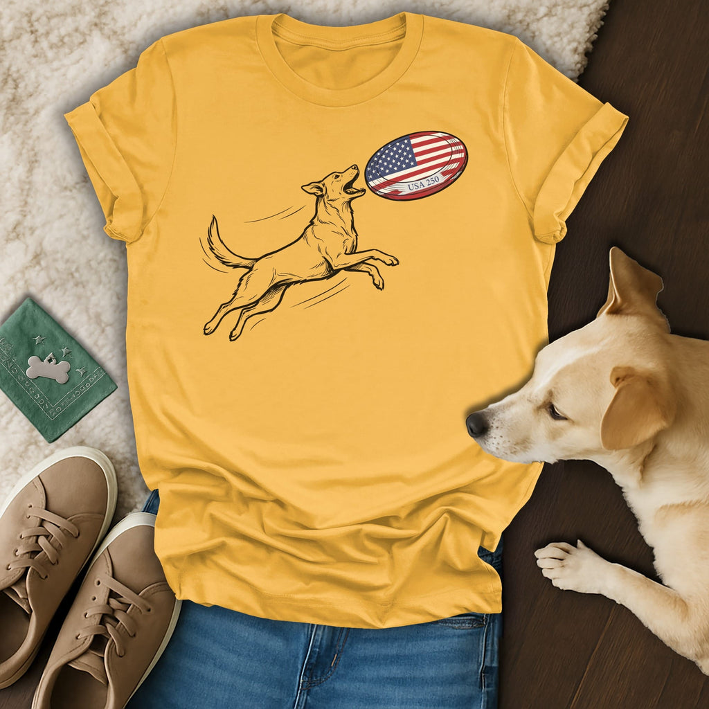 Dog jumping to catch an American flag football on a yellow t-shirt.