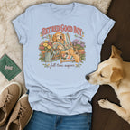 Light blue t-shirt featuring a retro cartoon of a golden retriever relaxing, surrounded by potted plants.