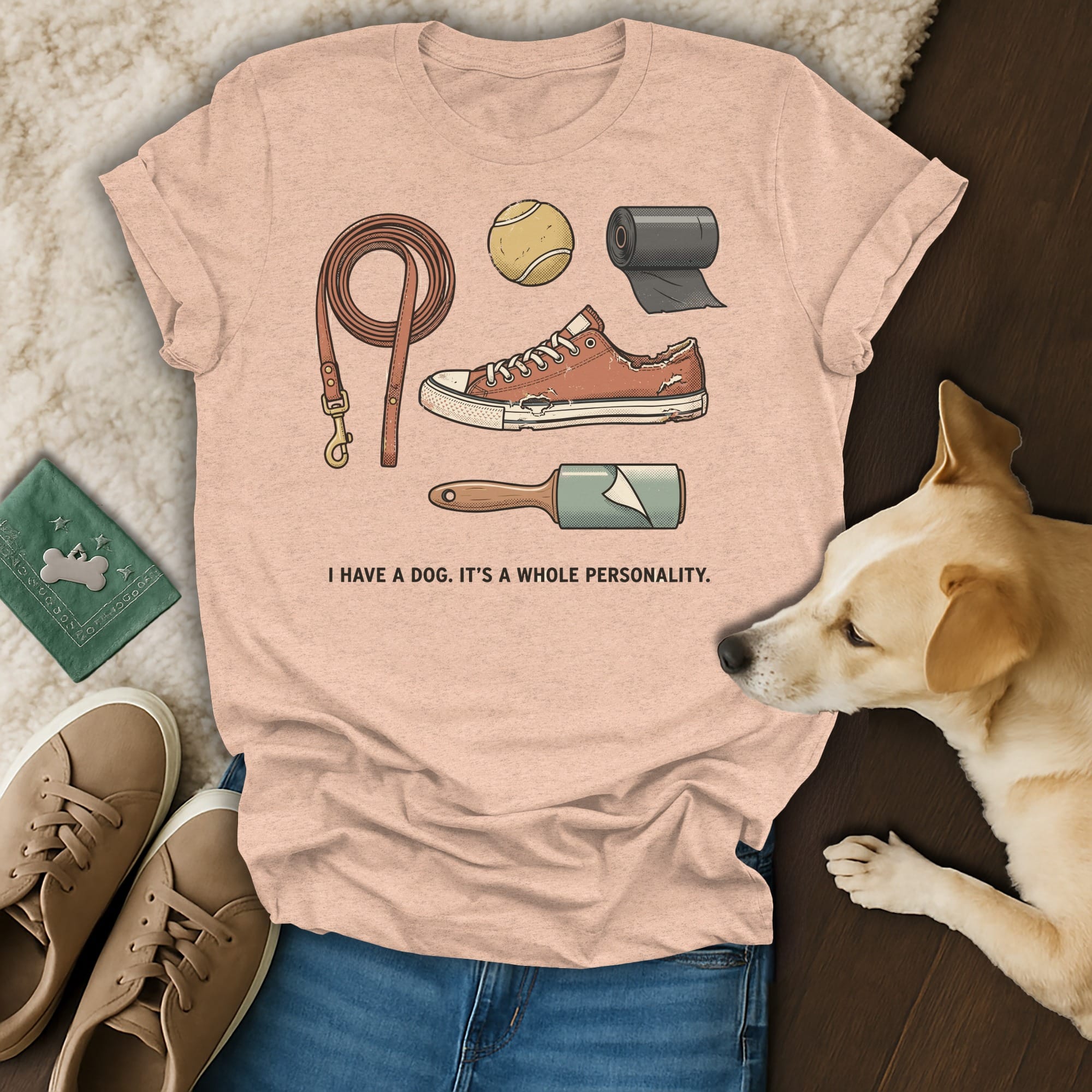 Peach t-shirt with dog accessories and text: I HAVE A DOG. IT'S A WHOLE PERSONALITY.